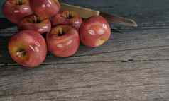 红色的苹果模糊小刀木处理灰色的木