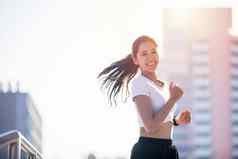 微笑亚洲年轻的健身体育运动女人运行运动型