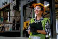 漂亮的工厂女人工人技术员微笑持有文档文件