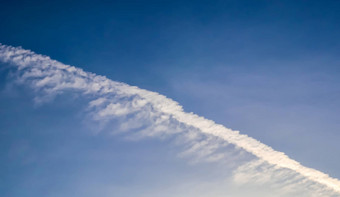 飞机冷凝航迹云的蓝色的天空中间画