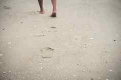 年轻的女人走海滩光着脚