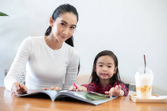亚洲妈妈。教学女儿读书学期打破生活表格冷牛奶表格首页教育概念活动家庭