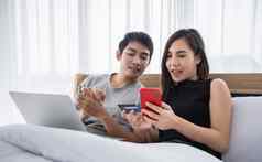 亚洲夫妇购物在线支付信贷卡移动PC移动电话首页快乐夫妇首页冲浪网床上