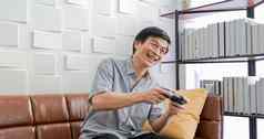 高级亚洲男人。平板电脑虚拟现实模拟器玩游戏生活房间感觉快乐生活方式高级家庭首页概念