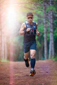 男人。跑步者小道运动员的脚穿体育鞋子小道运行森林