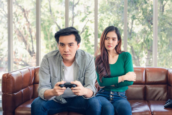 肖像女人感觉冒犯了的男朋友玩视频游戏坐着沙发上生活房间夫妇爱的关系生活方式概念
