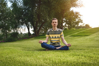 年轻的男人。冥想在户外<strong>公园</strong>坐着眼睛关闭手享受自然瑜伽冥想概念精神上的<strong>实践</strong>Zen