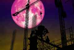 完整的粉红色的月亮回来轮廓工人建设建筑