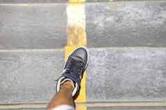 男人。腿长运动鞋走公共楼梯yello