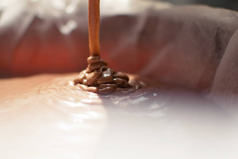特写镜头巧克力牛奶液体倒形式糖果注射器形式<strong>模具模具</strong>准备巧克力糖果饼干烹饪过程