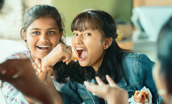 少年抓住食物朋友年轻的女孩开玩笑地战斗零食朋友概念朋友有趣的食物大学餐厅