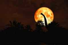 血月亮回来轮廓恐龙古老的公园红色的晚上