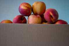 成熟的桃子堆放盒子收获桃子花园
