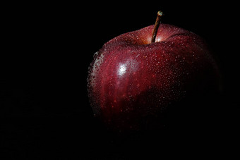 关闭新鲜的红色的苹果水滴孤立的黑色的背景- - - - - -低调宏拍摄