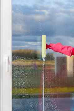 有吸引力的妻子洗窗口戴着手套手清洁窗口破布喷雾洗窗户清洁服务概念