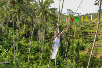 年轻的女孩摇摆摇摆不定的高峡谷年轻的旅游女人摆动悬崖丛林热带雨林热带tegalalang巴厘岛摇摆不定的暂停椰子树爱巴厘岛