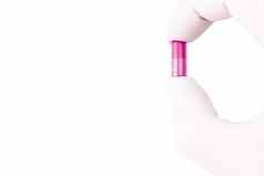 手医疗手套持有塑料粉红色的颜色有机跟胶囊孤立的白色背景特写镜头