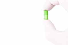 手医疗手套持有不明飞行物绿色颜色有机跟胶囊孤立的白色背景特写镜头