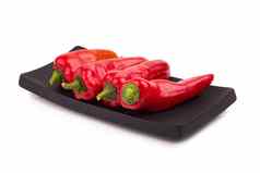 红色的辣椒蔬菜黑色的板孤立的白色背景