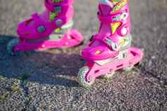 儿童脚粉红色的儿童辊特写镜头辊溜冰鞋户外体育