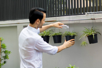 年轻的但浇水植物盆栽植物可<strong>回收</strong>的<strong>塑料</strong>瓶浇水植物扭曲的<strong>塑料</strong>瓶<strong>回收</strong>年轻的男人。工作花园