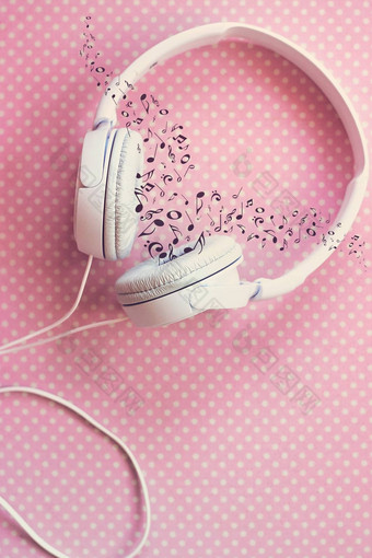 白色耳机粉红色的背景音乐的笔记