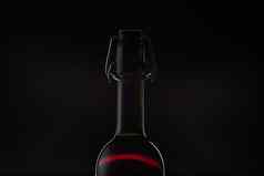 玫瑰酒红色的酒瓶金属开瓶器软木塞黑暗背景
