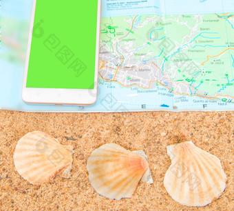 绿色屏幕色度智能手机旅游地图贝壳沙子电话屏幕取代概念旅游前视图