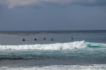 身份不明的男人。冲浪董事会等待波蓝色的水回来视图年轻的男孩等待波冲浪者等待行波冲浪者等待波海阳光明媚的热带一天