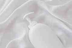 空白标签化妆品容器瓶产品模型白色丝绸背景
