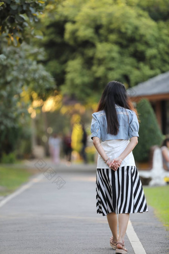 肖像亚洲女人通过公园自然背景