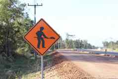 橙色标志显示象征图像人持有铲标志安装一边建设路警告标志指示路工作之前