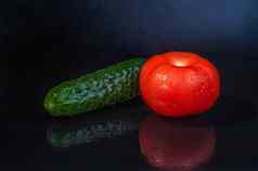 新鲜的蔬菜绿色黄瓜红色的番茄孤立的黑色的背景反射