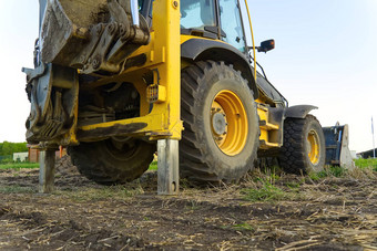 黄色的挖掘机黄色的拖拉机场建设机械场大黄色的轮加载程序对齐一块土地建筑拖拉机农田