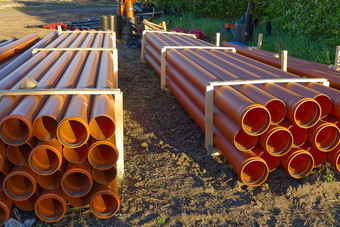 橙色下水道管道建设网站地下橙色塑料管道堆放聚氯乙烯橙色管道