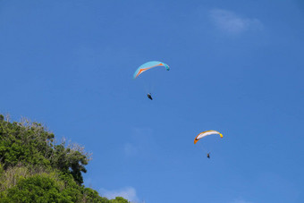 跳<strong>伞</strong>天空单<strong>滑翔伞</strong>飞行明亮的阳光明媚的一天热带巴厘岛岛美丽的<strong>滑翔伞</strong>绿马术背景概念活跃的生活方式极端的体育运动