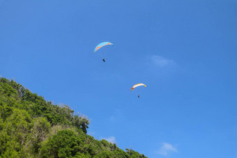 跳<strong>伞</strong>天空单<strong>滑翔伞</strong>飞行明亮的阳光明媚的一天热带巴厘岛岛美丽的<strong>滑翔伞</strong>绿马术背景概念活跃的生活方式极端的体育运动