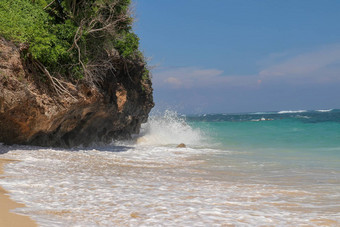 海滩山伞海滩细金沙子巴厘岛绿<strong>松石</strong>蓝色的水转海泡沫波打破岩石悬崖海岸阳光明媚的一天蓝色的天空旅游自然概念