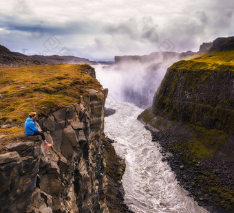 徒步旅行者坐着边缘古佛斯瀑布瀑布冰岛