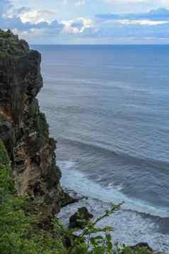 概述全景海洋海岸悬崖日落巴厘岛不知所措场景花green-capped垂直悬崖印度海洋南巴厘岛岛普拉崇高Uluwatu寺庙印尼