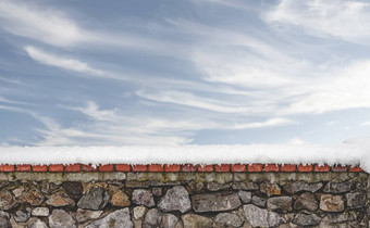 石头墙覆盖雪天空背景