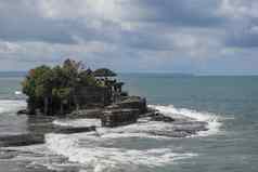 波粉碎悬崖前印度教寺庙土地很多寺庙建岩石海海岸巴厘岛岛印尼郁郁葱葱的热带植被前悬崖