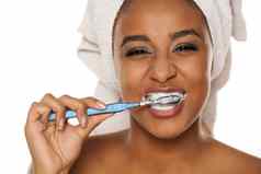 肖像快乐年轻的皮肤黝黑的女人刷牙牙齿