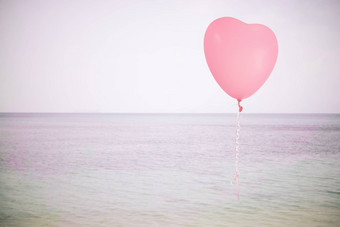 难看的东西粉红色的气球海天空背景复古的过滤器