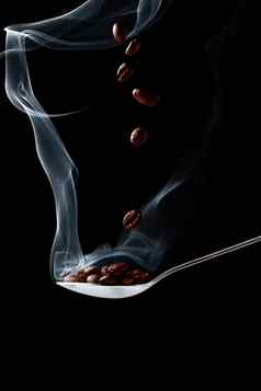 勺子热咖啡豆子烟黑色的背景下降咖啡豆子