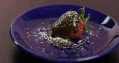 成熟的多汁的草莓融化了黑暗巧克力糖衣糖粉