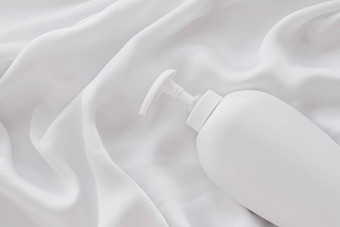 空白标签化妆品容器瓶产品模型白色丝绸背景