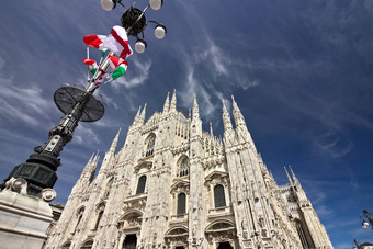 米兰大教堂外观旗帜蓝色的天空旗帜挥舞着