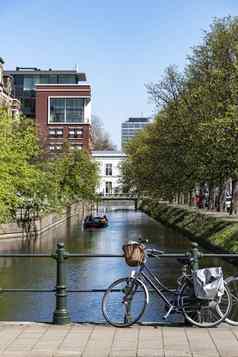 荷兰休闲自行车停车栅栏小桥路平静运河黑格城市万里无云的天空荷兰