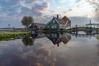 长曝光反射木绿色房子超过黑暗橙色颜色屋顶反映了平静水运河